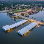 Aerial view of the DeCordova Bend Estates lake community on Lake Granbury at dusk, with covered boat docks and waterfront homes