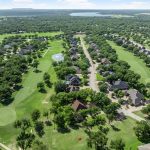Aerial view of the Pecan Plantation golf course community in Granbury, Texas, with homes lining the fairways and a pond along the course